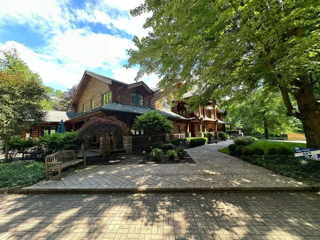 A Shaded Backyard Creates a Private Resting Area in an Austintown Home as the Stained Log Cabin Shines.