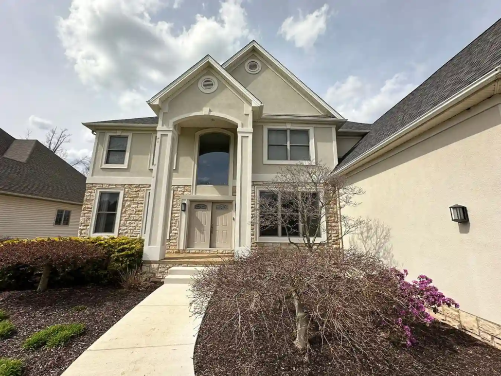 A Two Story Modern Home in Howland with a Newly Painted Beige Exterior Stands Out During the Fall Morning.