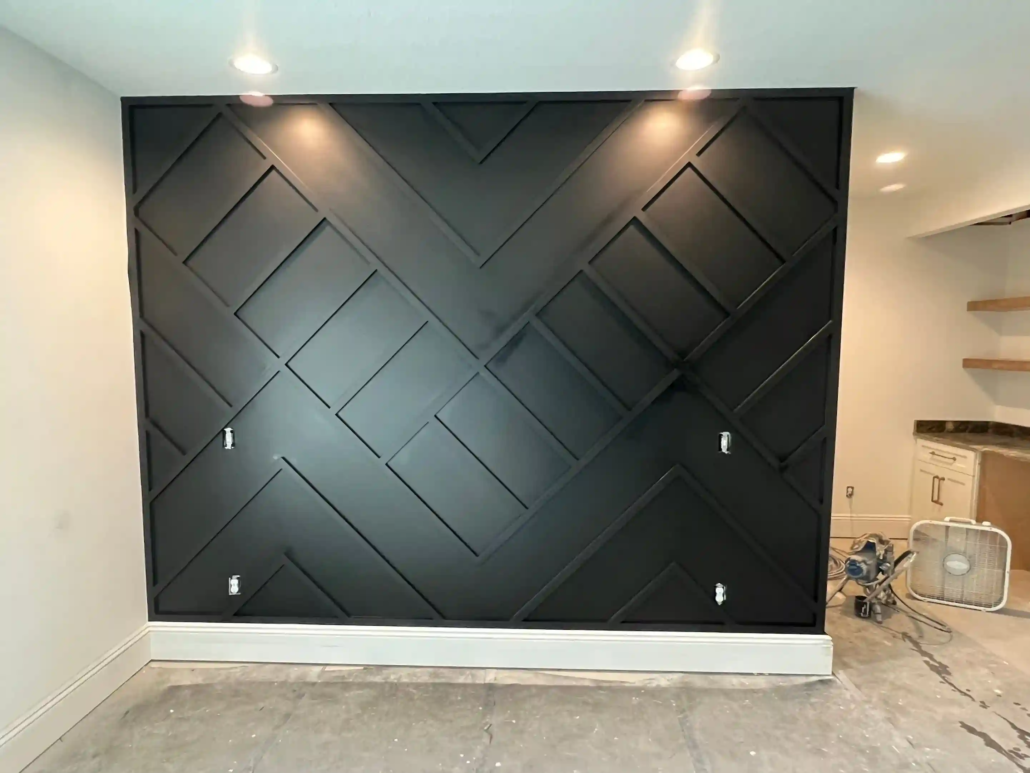 A Gray Interior Accent Wall with White Trim Shines Brightly with Recessed Lights Reflecting Off of Them.