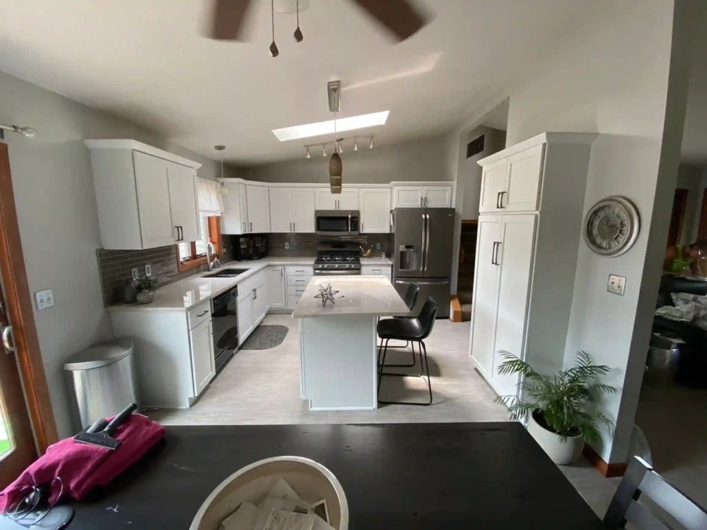 Light Coming in Through a Kitchen Skylight Shines on the Freshly Painted White Cabinets.