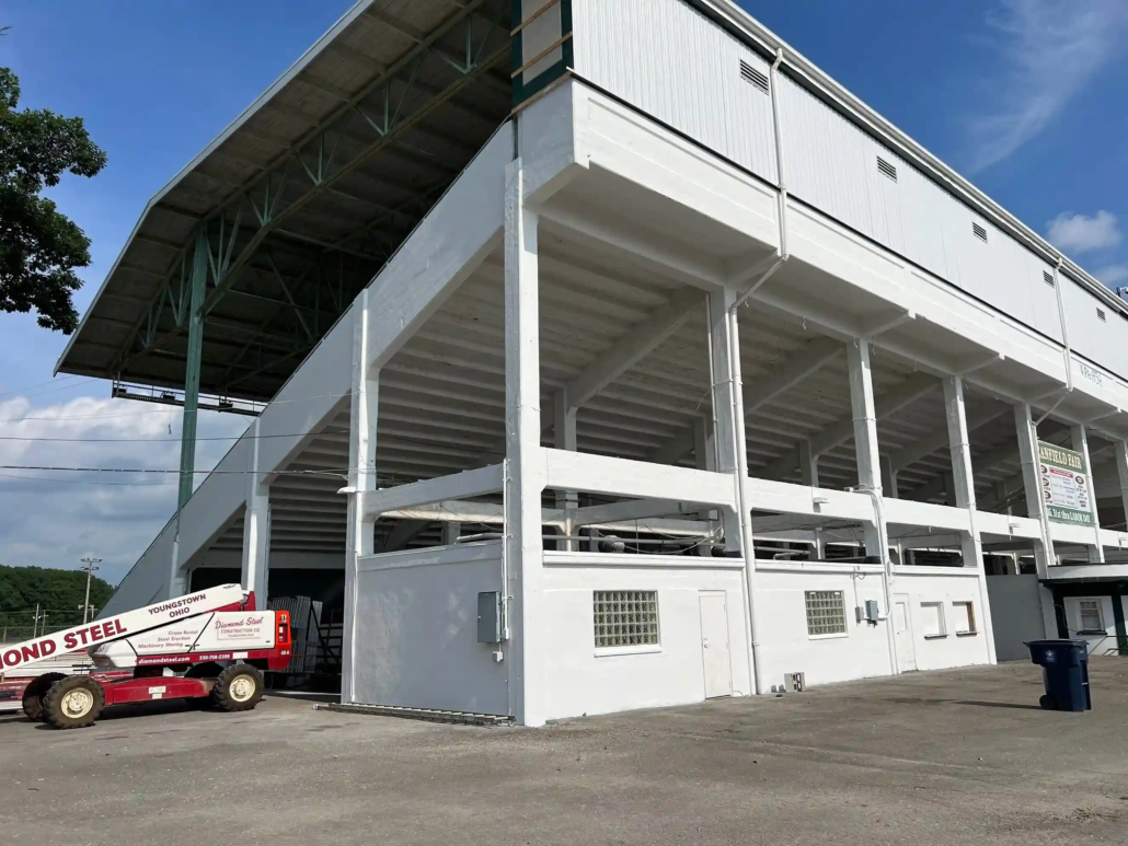 A Lift Sits Next to the Freshly Painted Canfield Fairgrounds Grandstands, Being Shined Upon by the Summer Sun.