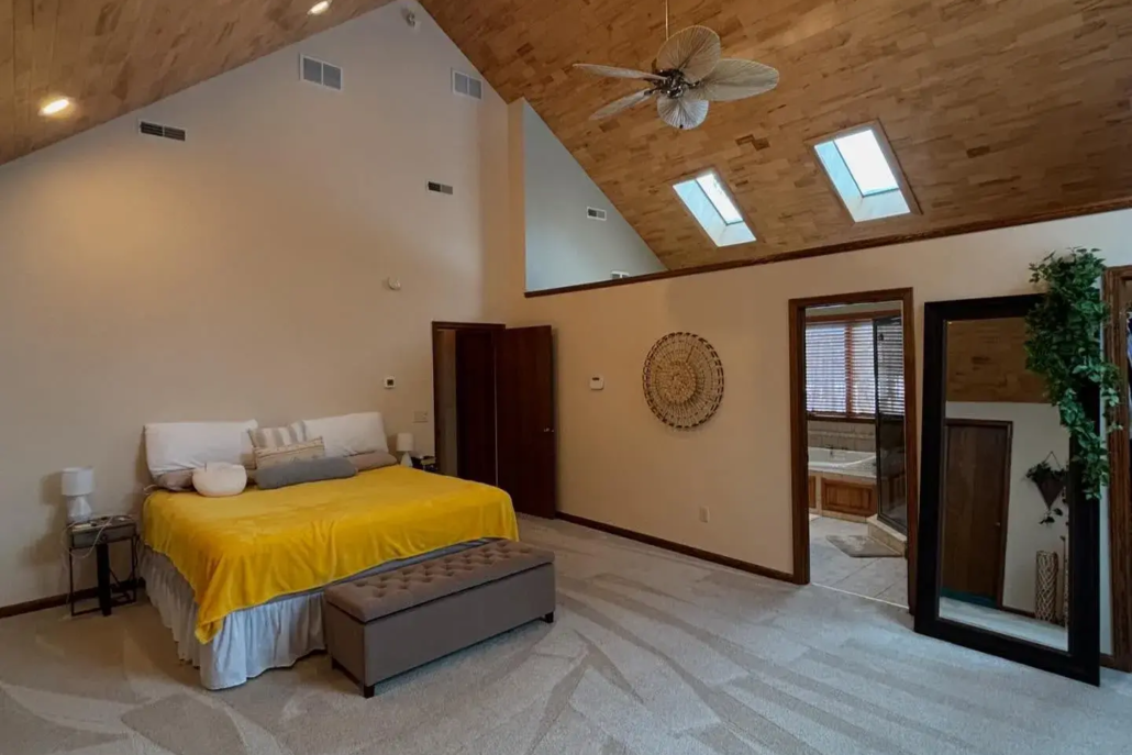 Bright Light Enters a White Painted Bedroom with an Oak Wood Accent Ceiling.